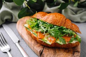 fijnproever gerookt Zalm croissant Aan houten bord foto