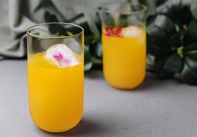 verfrissend oranje cocktail met bloemen ijs kubussen foto