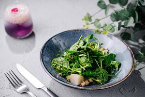 vers groen salade Aan modieus bord met luxe drinken foto