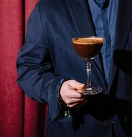 Mens in pak Holding espresso martini cocktail foto