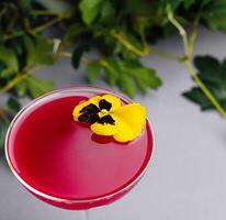 elegant roze cocktail met eetbaar bloem garneer foto