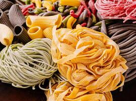 kleurrijk pasta assortiment Aan houten bord foto