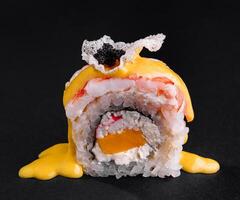 fijnproever sushi rollen met mango saus Aan zwart achtergrond foto