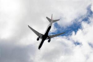 wit passagier vliegtuig vliegend in de lucht verbazingwekkend wolken in de achtergrond foto