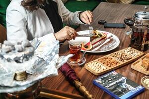 persoon zittend Bij tafel met bord van voedsel foto