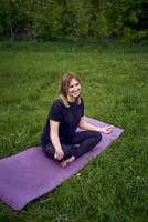 een vrouw en meisje Doen yoga en mediteren in natuur foto