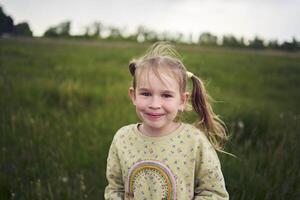 een mooi blond meisje met haar speelgoed- konijn is spelen in de veld- foto