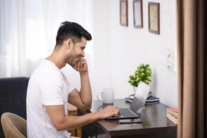 knap glimlachen Mens maken online telefoontje Aan laptop foto