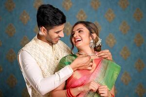 een glimlachen paar in Indisch outfits presenteren ketting naar zijn vrouw Aan verjaardag of diwali foto