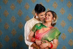romantisch liefde paar in traditioneel Indisch outfits de man omarmt zijn vrouw van achter foto