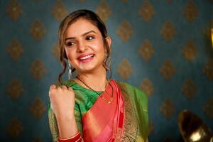 mooi dame in Saree gedurende diwali festival grijnzend en poseren in voorkant van de camera foto