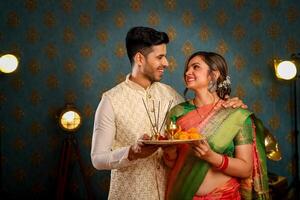 romantisch paar in Indisch traditioneel kleding Holding puja bord in hand- foto