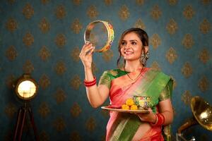 beeld van heet Indisch vrouw in traditioneel Indisch kleding aan het doen karwa chauth rituelen foto