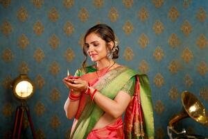 een onschuldig dame in Saree vieren diwali terwijl Holding diya foto