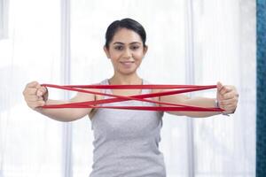 sexy vrouw uitrekken weerstand band het uitvoeren van arm training foto