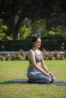 vrouw yoga mentor sluitend haar ogen en zittend in vajrasana asana. foto