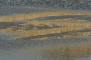 reflectie van de wolken in de water Aan de zand noorden zee Bij petten, de Nederland foto