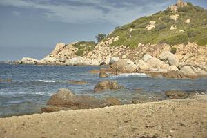 rotsen ontspruiten uit de zee op het strand van cala sa figu. foto