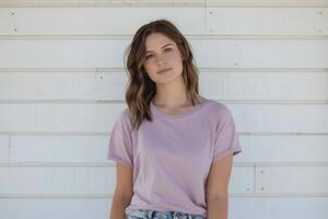 een jong vrouw met lang bruin haar- vervelend een mauve t-shirt is staand in voorkant van een wit muur. foto