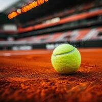 een dichtbij omhoog van een tennis bal Aan een klei rechtbank met de stadion lichten uit van focus in de achtergrond foto