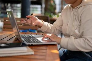 een vrouw reageren naar e-mails Aan haar laptop computer, typen Aan de toetsenbord, en werken online. foto