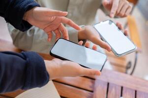 twee mensen sharing contact info of overbrengen bestanden door brengen twee smartphones dichtbij samen. foto