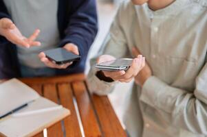 twee mensen sharing contact info of overbrengen bestanden door brengen twee smartphones dichtbij samen. foto