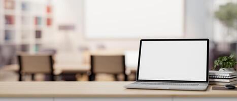 een laptop computer mockup Aan een tafel met een wazig achtergrond van een hedendaags vergadering kamer foto