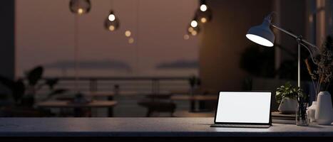 een digitaal tablet met een wit scherm mockup Aan een tafel in een restaurant in de avond. foto