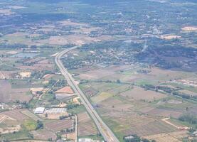 antenne visie van agrarisch veld, rivier, weg, en stadsgezicht is gezien door de vliegtuig venster foto