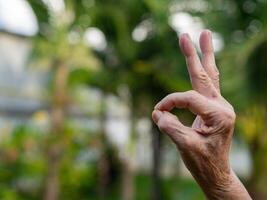 hand- van een senior vrouw tonen OK symbool met kopiëren ruimte voor tekst foto