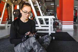 portret van een vrolijk sport- vrouw gebruik makend van smartphone in geschiktheid Sportschool. foto