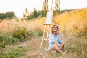 mooi getalenteerd vrouw schilder schilderij Aan ezel, maken kleurrijk schetsen, creëren marinier landschap. mooi vrouw artiest schilderij met waterverf verven. creativiteit en verbeelding concept foto