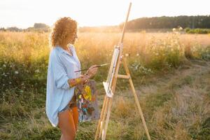 mooi getalenteerd vrouw schilder schilderij Aan ezel, maken kleurrijk schetsen, creëren marinier landschap. mooi vrouw artiest schilderij met waterverf verven. creativiteit en verbeelding concept foto