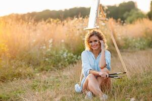 mooi getalenteerd vrouw schilder schilderij Aan ezel, maken kleurrijk schetsen, creëren marinier landschap. mooi vrouw artiest schilderij met waterverf verven. creativiteit en verbeelding concept foto