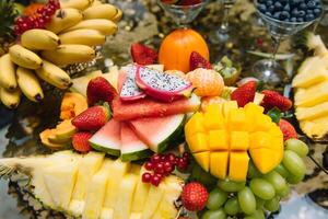 vers biologisch fruit achtergrond. gezond aan het eten concept. vers, exotisch, biologisch fruit, licht snacks in een bord Aan een buffet tafel foto