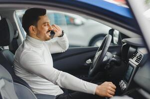 man praten op een mobiele telefoon tijdens het autorijden. foto