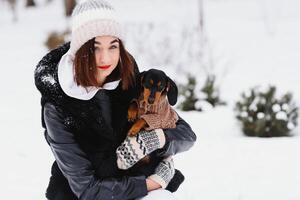 jong elegant vrouw met een hond hebben pret in een winter Woud. foto