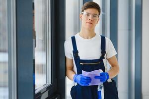 schoonmaak onderhoud kwam naar schoon nieuw huis. hardwerkend Mens voorzichtig schoon venster. kant visie foto