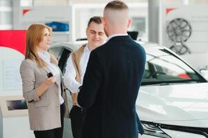 jong paar glimlachen Bij auto toonzaal. foto