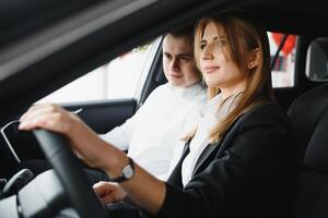 jong mooi vrouw tonen haar liefde naar een auto in een auto toonzaal. foto