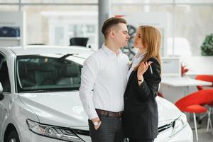 jong paar omzeilen een auto in een auto toonzaal. foto