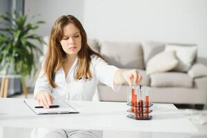 portret van een mooi vrouw chemicus op zoek analyseren een bloed test buis in een laboratorium. foto