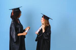 twee meisjes zijn poseren voor nemen foto in zwart jurken en houden diploma certificaat. ze zijn afgestudeerden en houden diploma certificaat. ze zijn gelukkig en in mooi zo humeur.