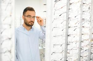 jong Mens kiezen bril Bij optiek winkel foto