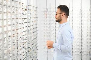 jong Mens kiezen bril Bij optiek winkel foto