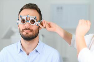 oogheelkunde concept. mannetje geduldig onder oog visie examen in gezichtsvermogen oogheelkunde correctie kliniek foto
