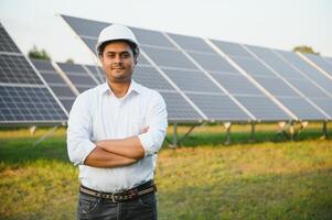 portret van een jong Indisch mannetje ingenieur of architect Bij een zonne- paneel boerderij. de concept van schoon energie foto