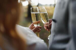 handen van bruid en bruidegom Holding Champagne bril met sprankelend wijn. bruiloft viering concept. foto