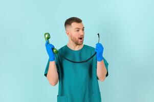 portret van jong mannetje dokter met telefoon, Aan blauw achtergrond foto